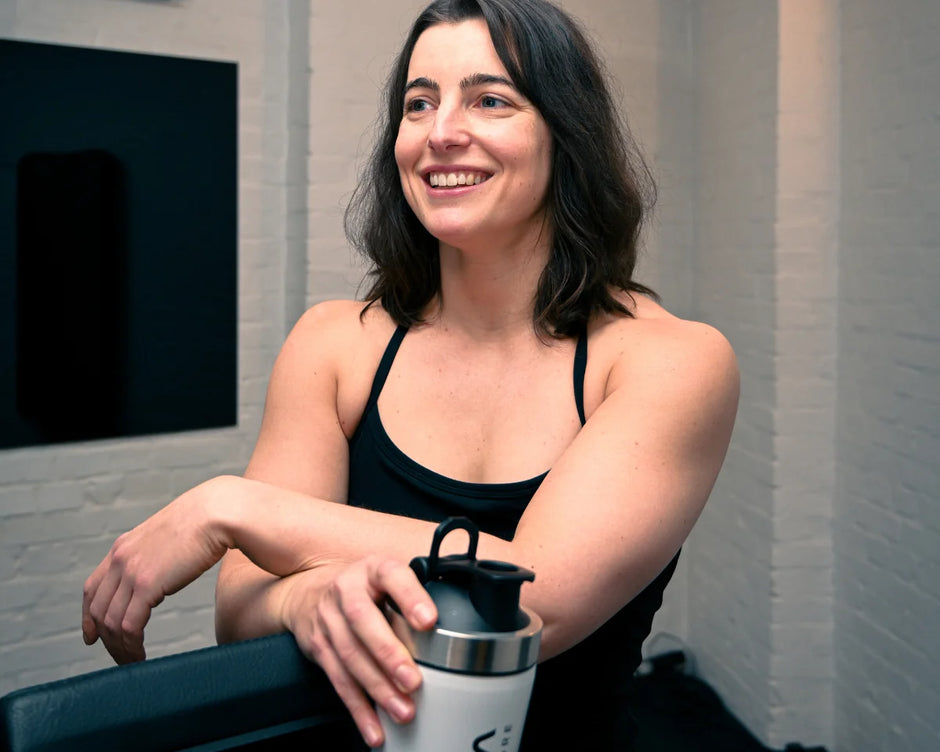 Smiling athlete in the gym holding a WAM shaker