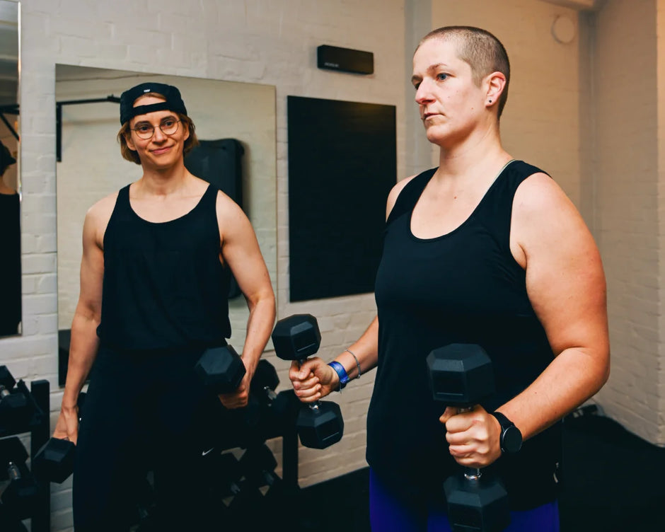 Zwei Personen trainieren mit Kurzhanteln im Gym